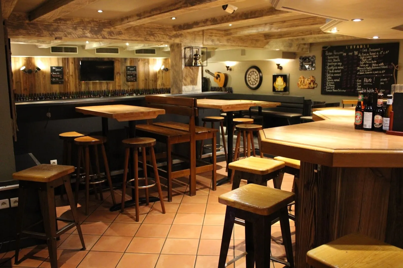 La salle : comptoir, tabourets en bois et murs en planches